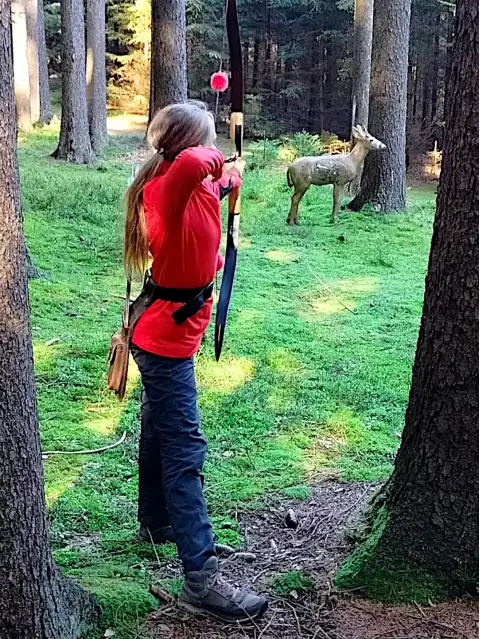 Mladá lukostřelkyně střílí na 3D terč srnky
