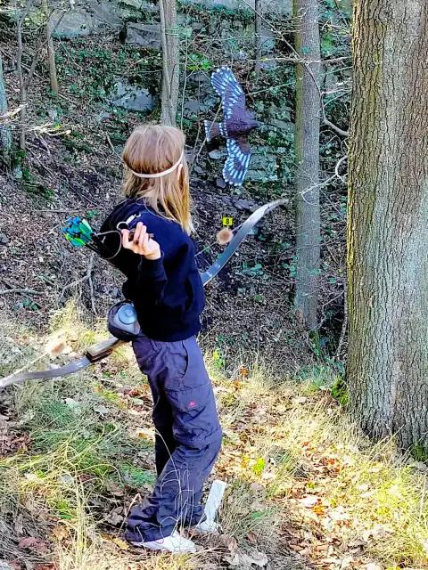 Dítě s lukem se připravuje k výstřelu na 3D terč sokola
